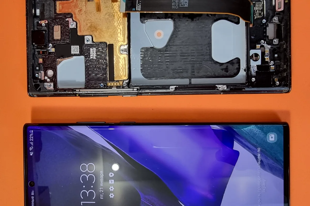 На оранжевом фоне лежат два Samsung Galaxy Note: один разобран до материнской платы, у второго горит экран блокировки