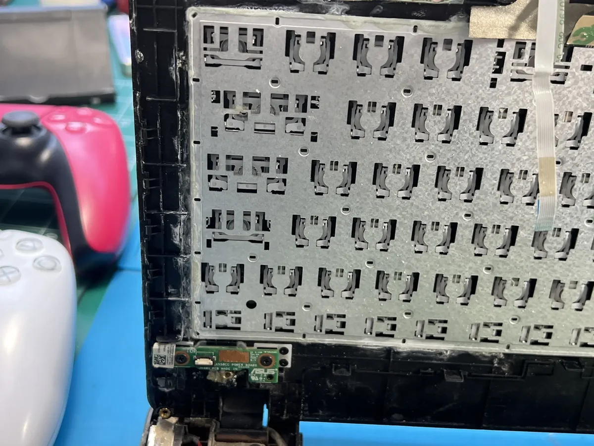 Клавиатура ноутбука Asus без колпачков: металлическая подложка, под каждую клавишу выштампованы два зацепа, справа уходит шлейф.