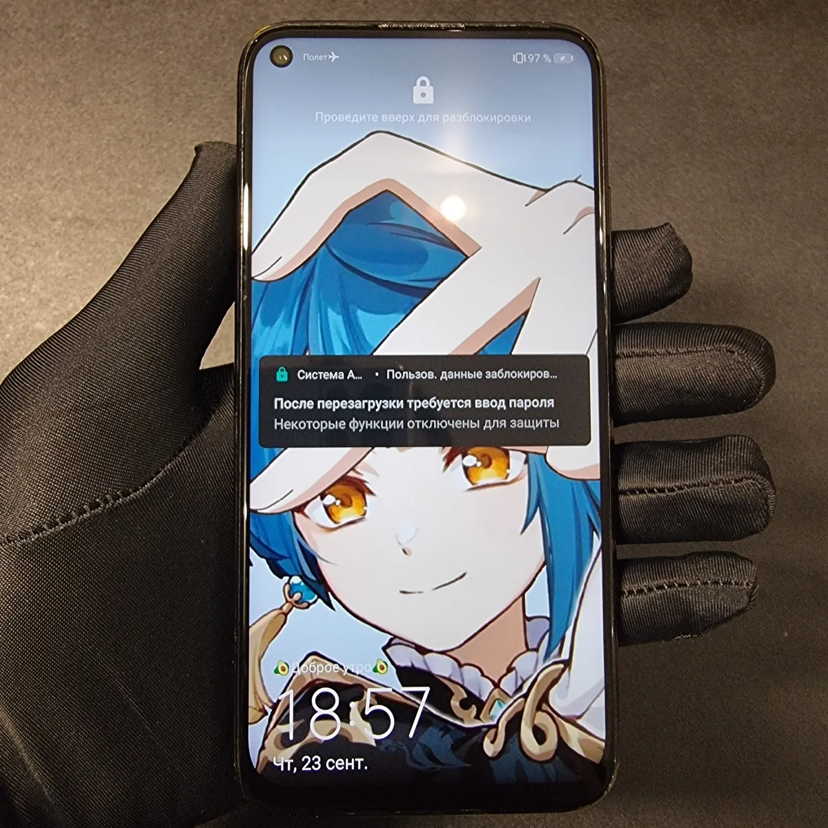 Смартфон на Android в руке в чёрной перчатке, на экране блокировки уведомление «После перезагрузки требуется ввод пароля»