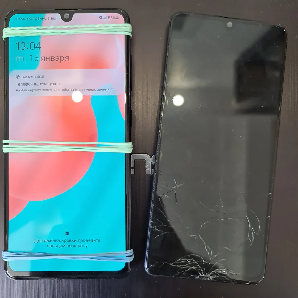 Samsung с новым дисплеем перетянут резинками, рядом лежит старый, с трещинами по краям.